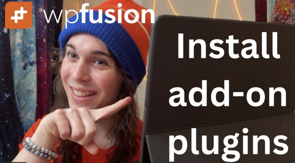 person wearing an orange beanie and red shirt points at a laptop screen. text on the image reads, download wp fusion add on plugins today. a logo with a plus symbol is in the top left corner.