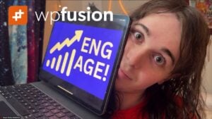 a person with long hair holds a tablet displaying engage! alongside wordpress insights, featuring an upward arrow and chart. the logo wpfusion appears in the top left corner. the colorful, blurred background adds energy to the advanced video metrics theme.